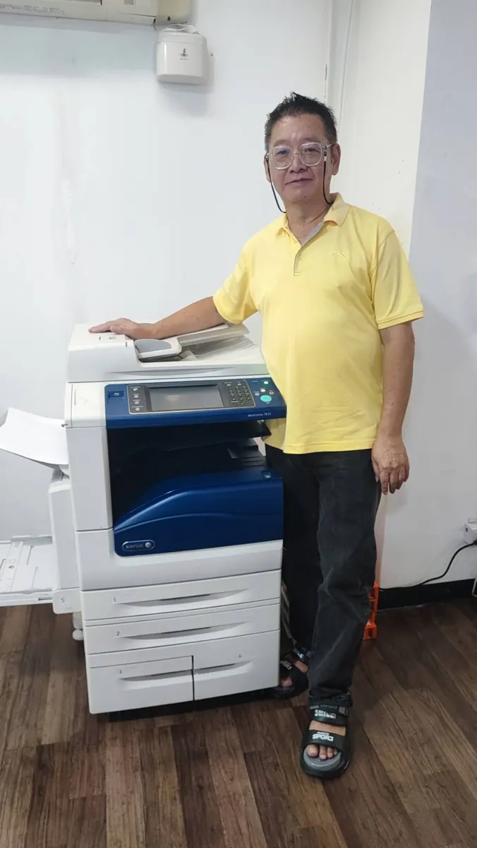 ลูกค้ายืนข้างเครื่องถ่ายเอกสาร Xerox WorkCentre หลังติดตั้งในสำนักงาน