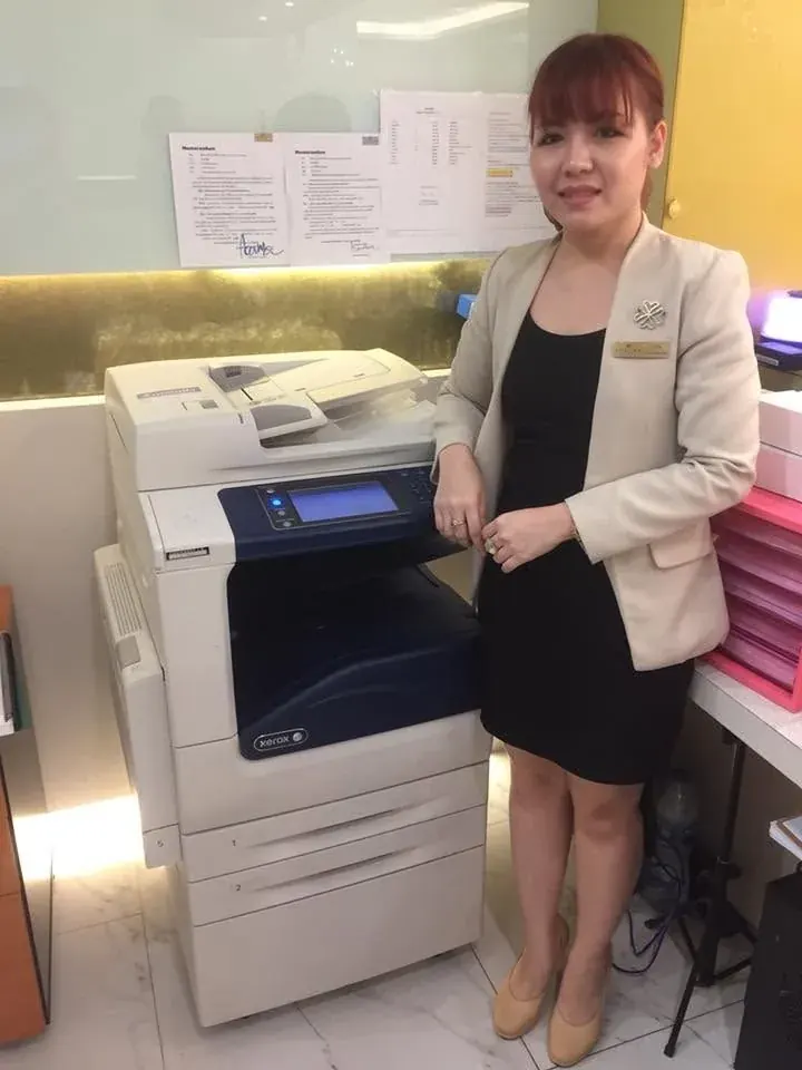 ลูกค้าธุรกิจโรงแรมยืนข้างเครื่องถ่ายเอกสาร Xerox ที่ติดตั้งแล้ว